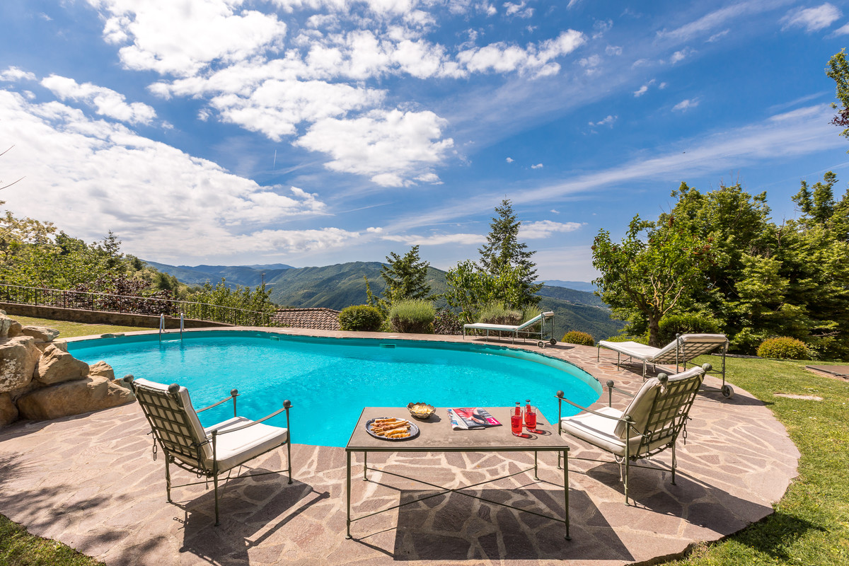 Ejemplo de piscina de estilo de casa de campo de tamaño medio tipo riñón en patio trasero con adoquines de piedra natural