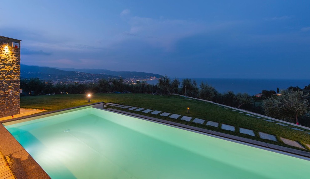 Esempio di una piscina a sfioro infinito moderna rettangolare di medie dimensioni e davanti casa