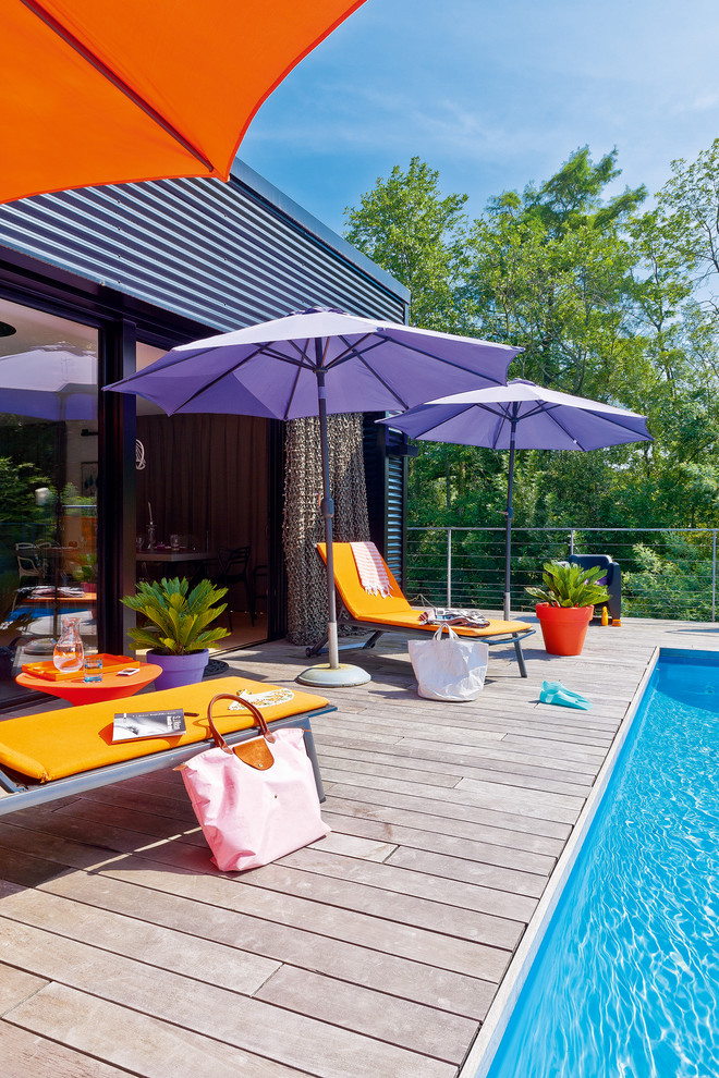 Cette image montre une piscine design de taille moyenne et rectangle avec une terrasse en bois.