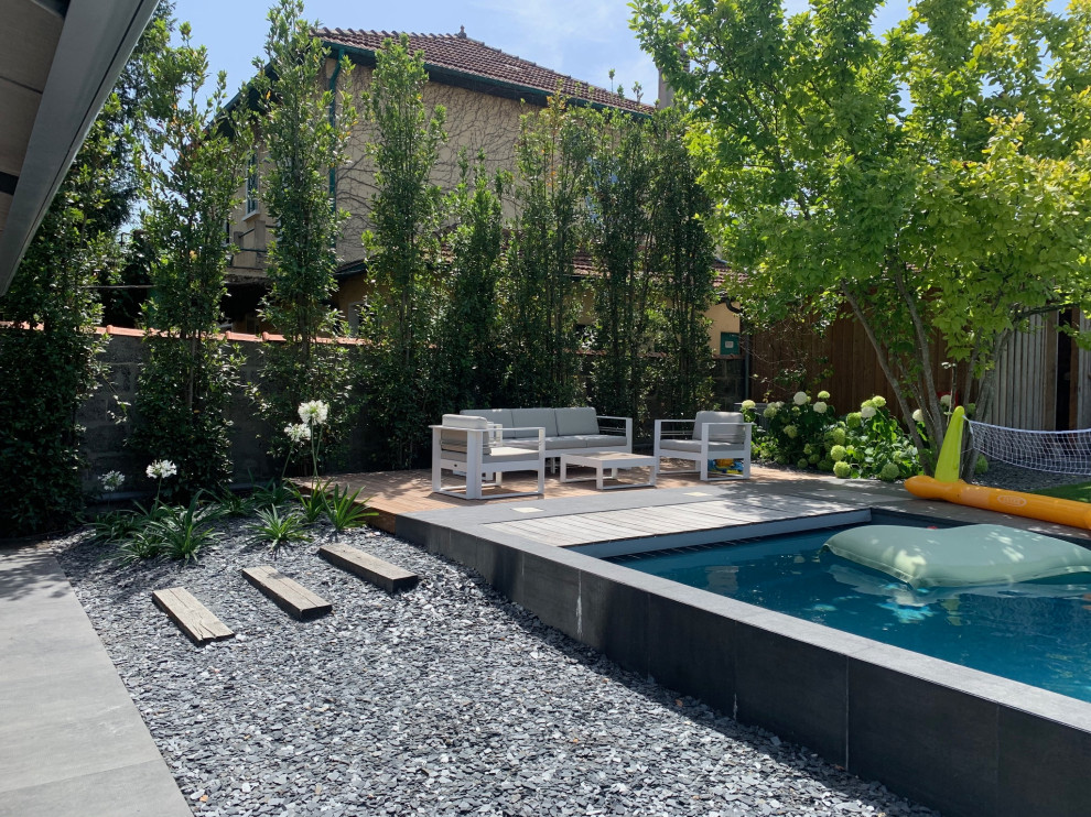 Imagen de piscina contemporánea grande en patio trasero con privacidad