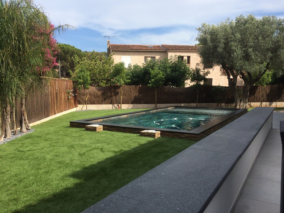 Large modern front rectangular natural swimming pool in Marseille with a water feature and tiled flooring.