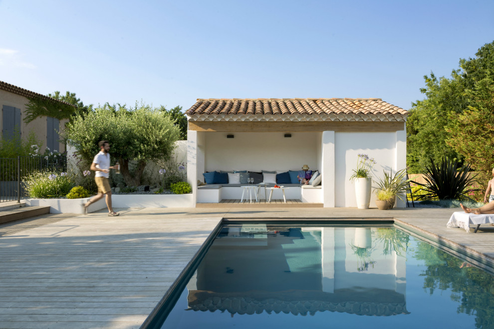 Réalisation d'une piscine méditerranéenne rectangle avec une terrasse en bois.