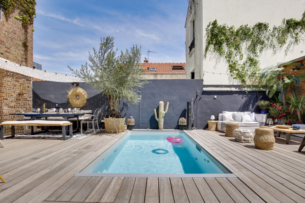 Photo of a contemporary rectangular swimming pool in Paris with decking.