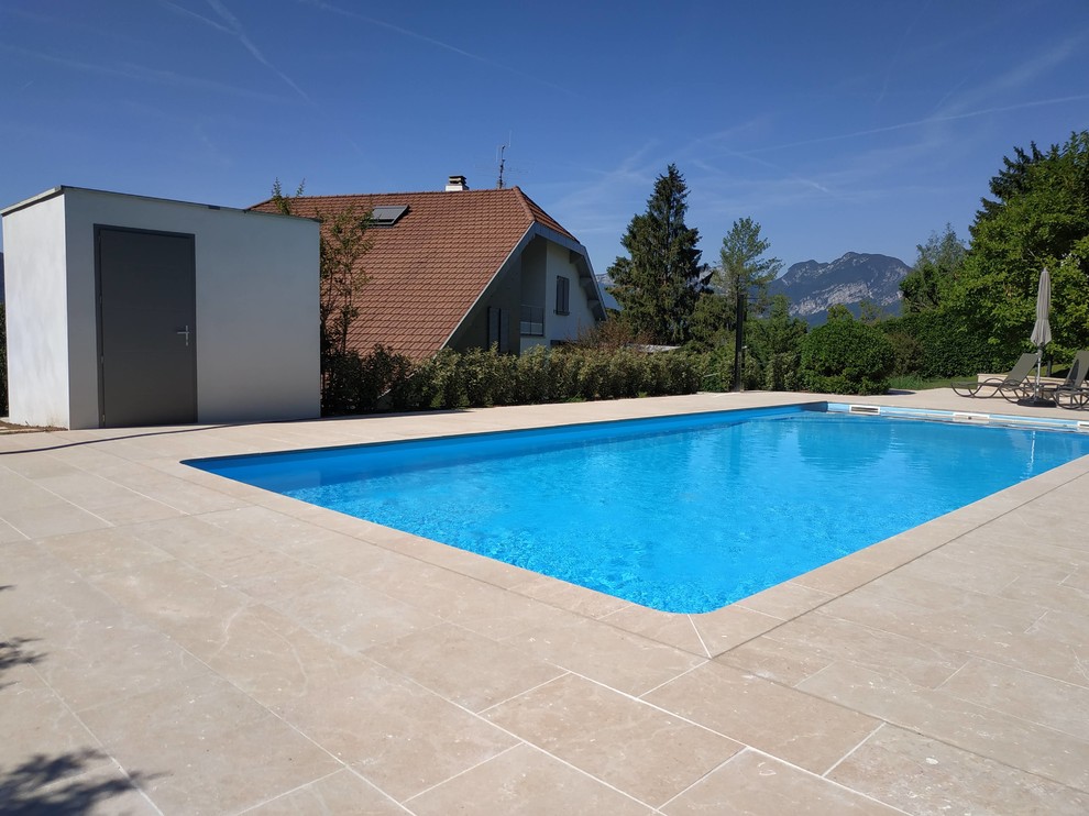 Idée de décoration pour une grande piscine latérale minimaliste rectangle avec des pavés en pierre naturelle.