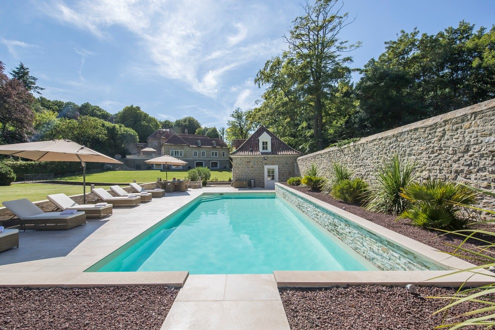 Idée de décoration pour une grande piscine champêtre rectangle avec du gravier.