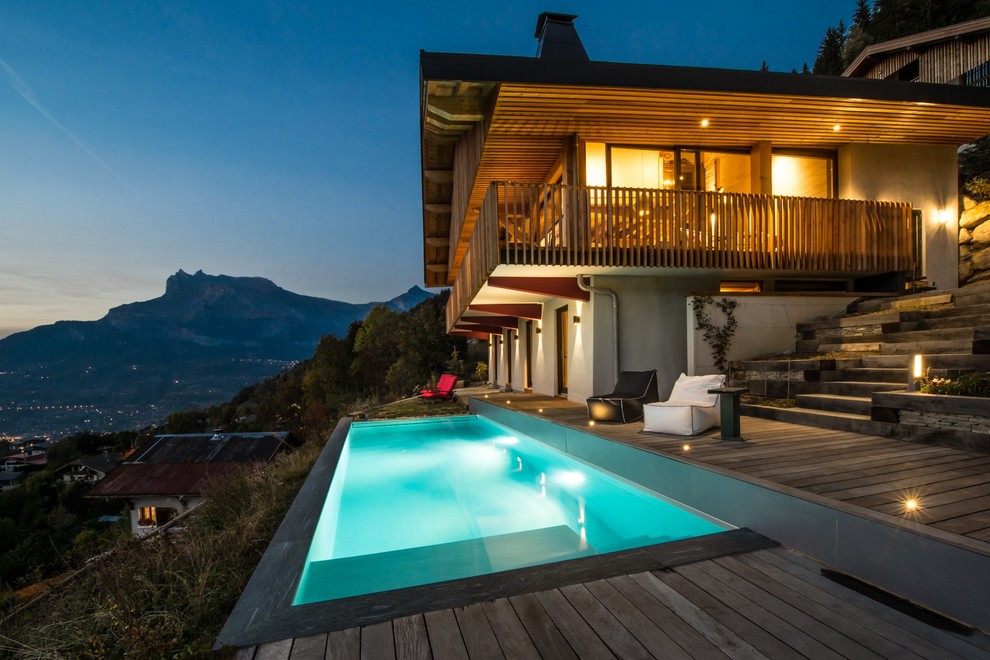 This is an example of a rustic front rectangular swimming pool in Grenoble with decking.