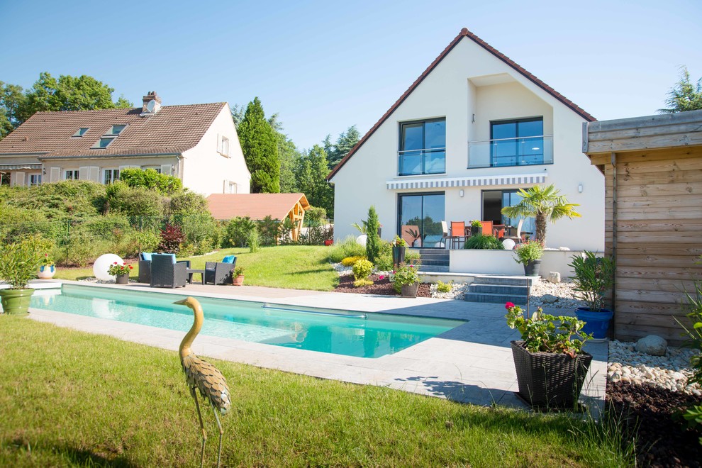 Ejemplo de casa de la piscina y piscina alargada de estilo de casa de campo grande rectangular en patio trasero