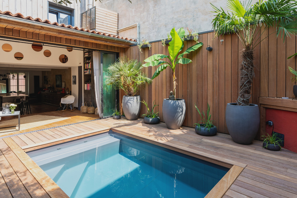 Modelo de piscina tropical pequeña en patio con entablado