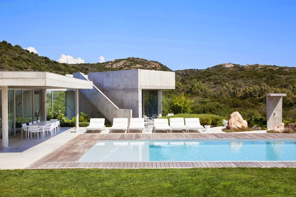 Inspiration pour une grande piscine design rectangle avec une terrasse en bois.