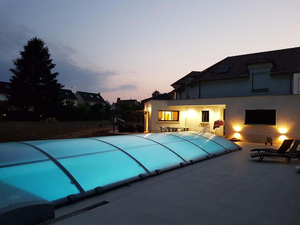 Immagine di una grande piscina moderna rettangolare davanti casa con una dépendance a bordo piscina