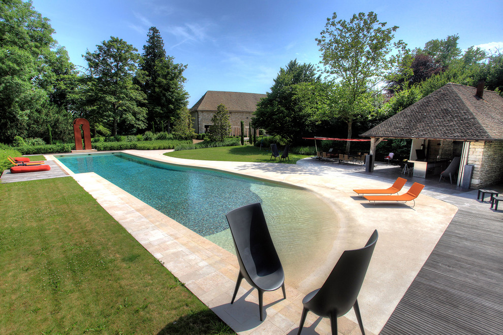 На фото: бассейн произвольной формы на заднем дворе в современном стиле с домиком у бассейна и настилом с