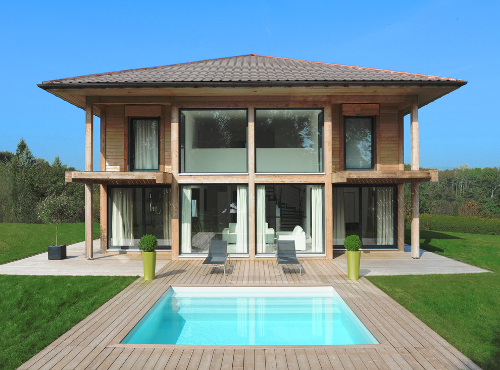Imagen de piscina actual rectangular en patio trasero con entablado