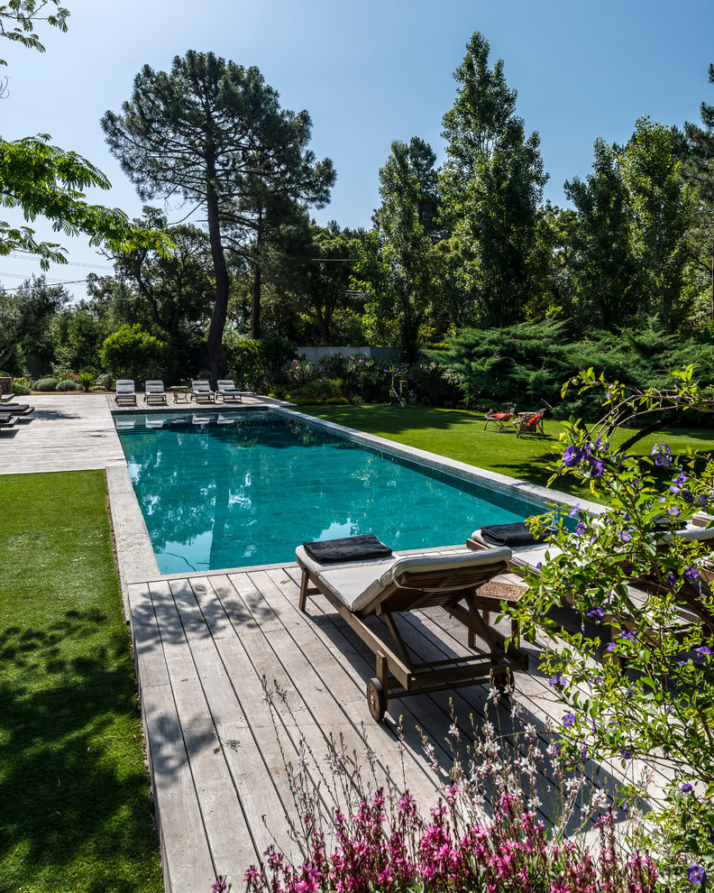 Ejemplo de piscina alargada contemporánea de tamaño medio rectangular en patio trasero con entablado