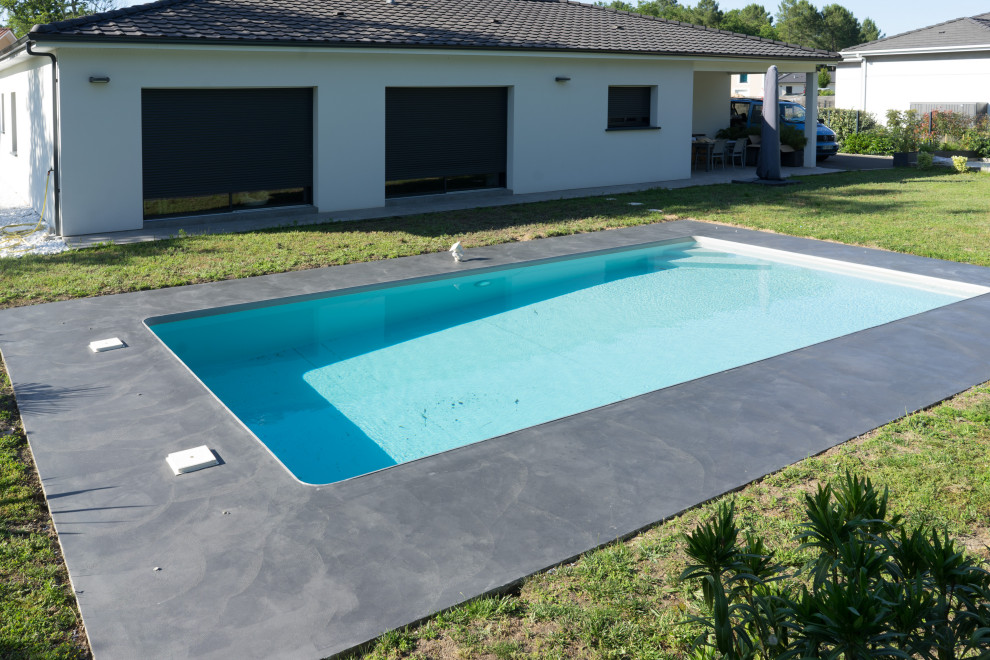 Example of a huge trendy courtyard stamped concrete and rectangular pool design in Bordeaux