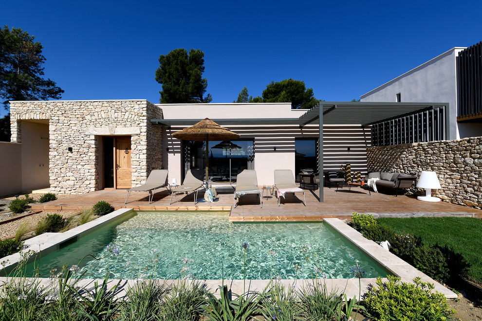 Exemple d'une piscine méditerranéenne en L de taille moyenne avec une terrasse en bois.