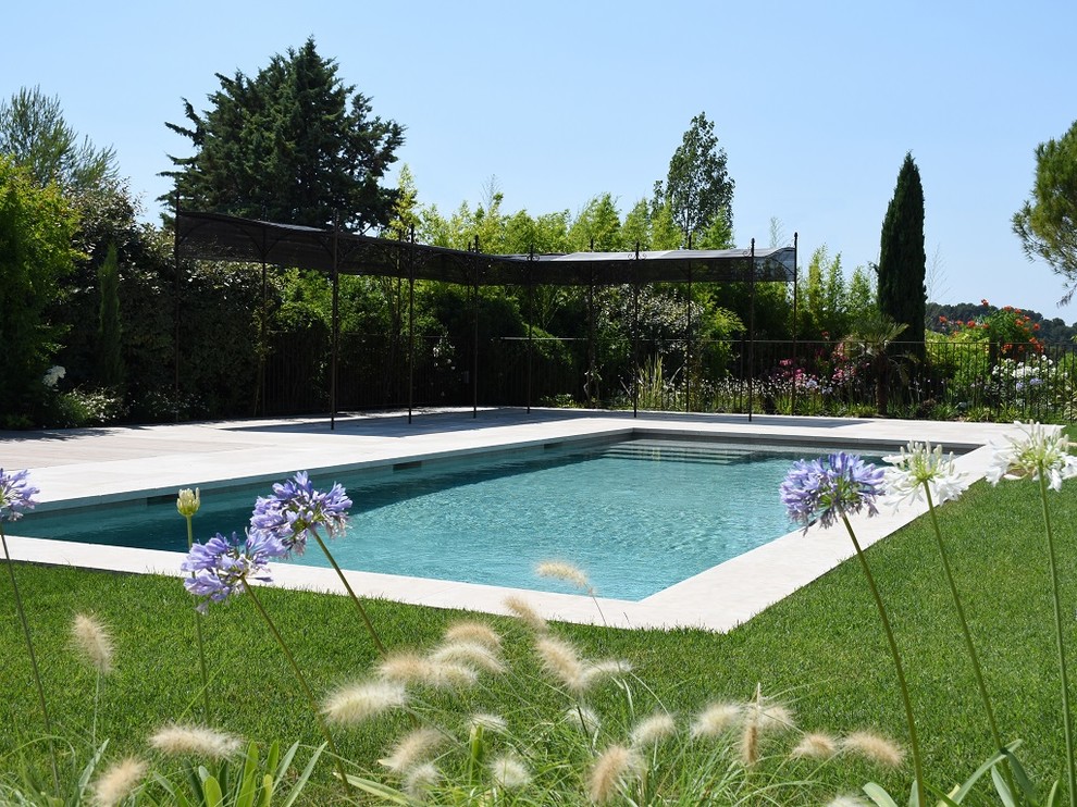 Imagen de piscina actual grande rectangular con adoquines de piedra natural