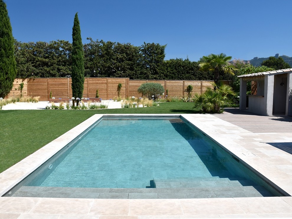Esempio di una grande piscina mediterranea rettangolare con pavimentazioni in pietra naturale