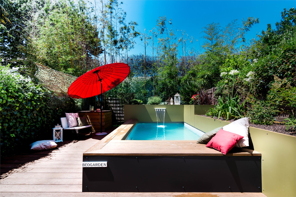 Idée de décoration pour une petite piscine design rectangle avec un point d'eau et une terrasse en bois.