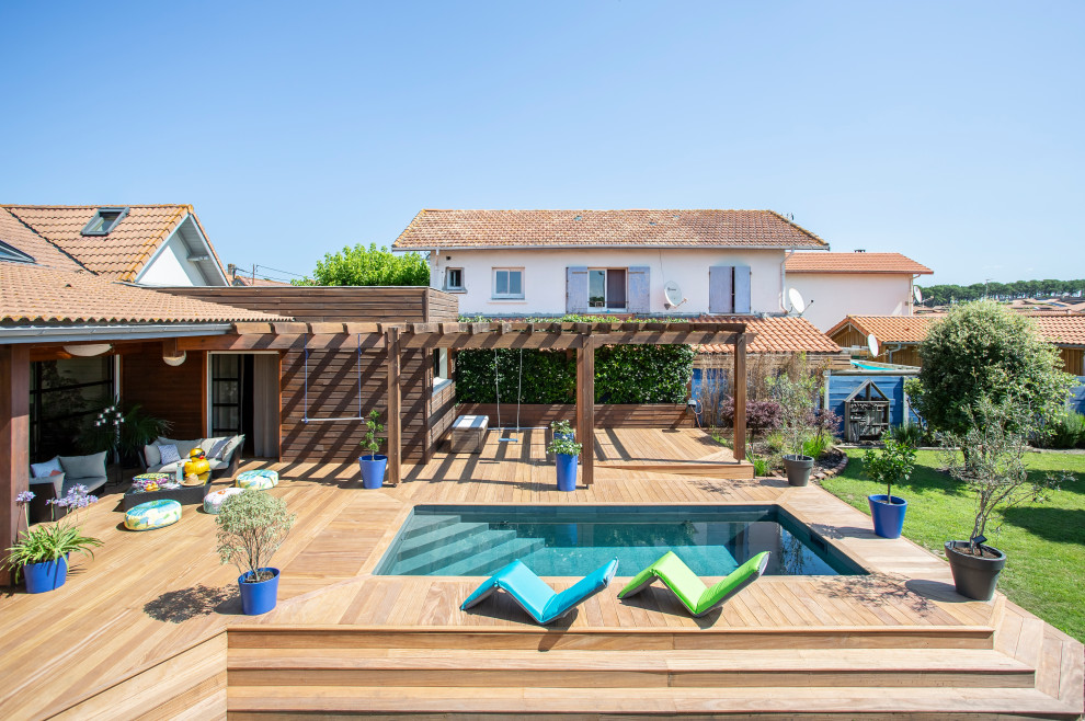 Exemple d'une petite piscine arrière méditerranéenne rectangle avec une terrasse en bois.