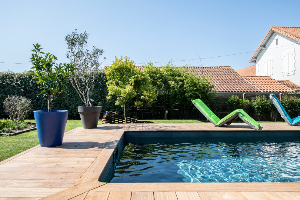 Exemple d'une petite piscine arrière méditerranéenne rectangle avec une terrasse en bois.