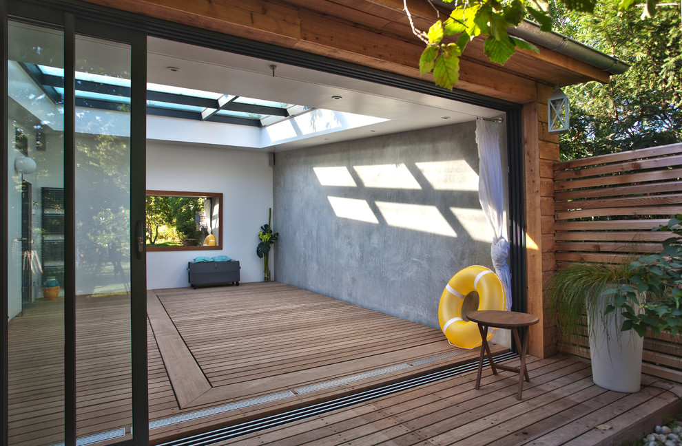Réalisation d'une piscine arrière design de taille moyenne et sur mesure avec une terrasse en bois.