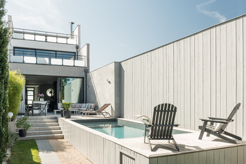 Inspiration for a medium sized contemporary back rectangular above ground swimming pool in Paris with a water feature and natural stone paving.