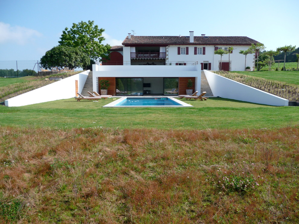 Modelo de piscina de estilo de casa de campo grande en patio trasero