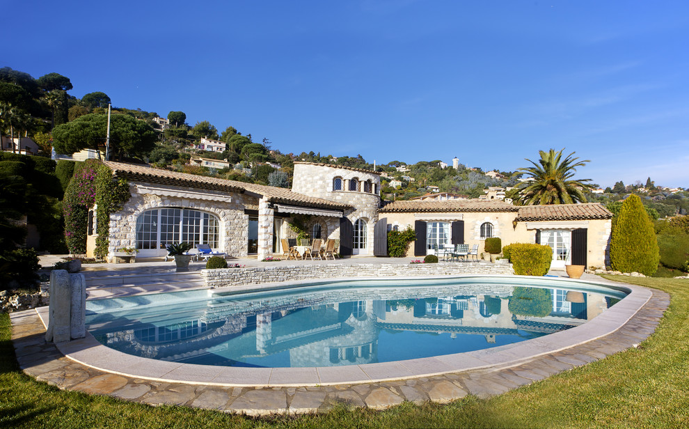 Foto de piscina mediterránea grande a medida en patio trasero