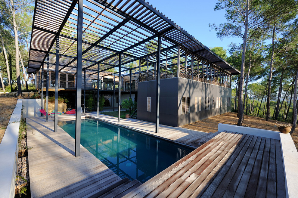 Imagen de piscina contemporánea de tamaño medio rectangular en patio trasero con entablado