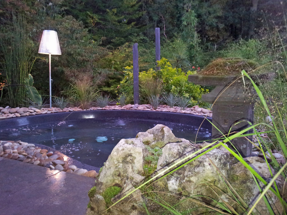 Esempio di una piccola piscina naturale etnica a "C" in cortile con una vasca idromassaggio e pavimentazioni in pietra naturale