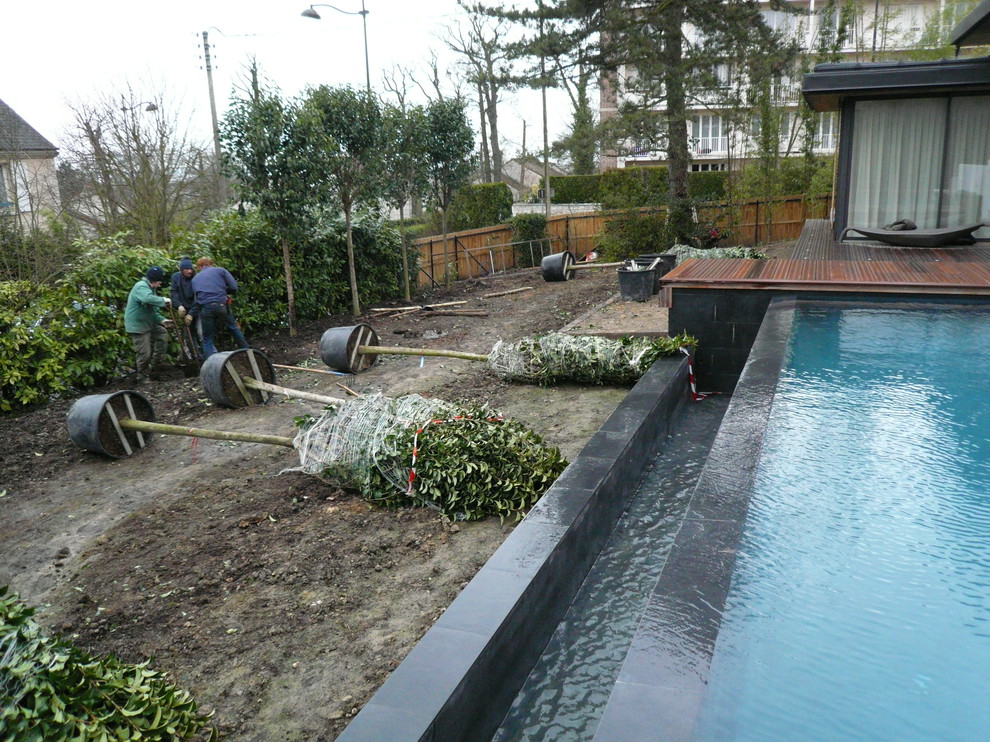 Diseño de piscina infinita de tamaño medio a medida en patio delantero con entablado