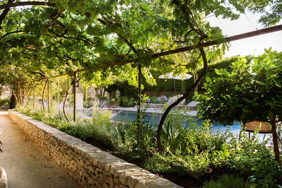 Esempio di una piscina mediterranea rettangolare con pavimentazioni in pietra naturale