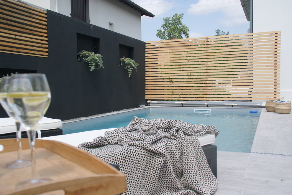 Immagine di una piccola piscina minimal dietro casa con piastrelle