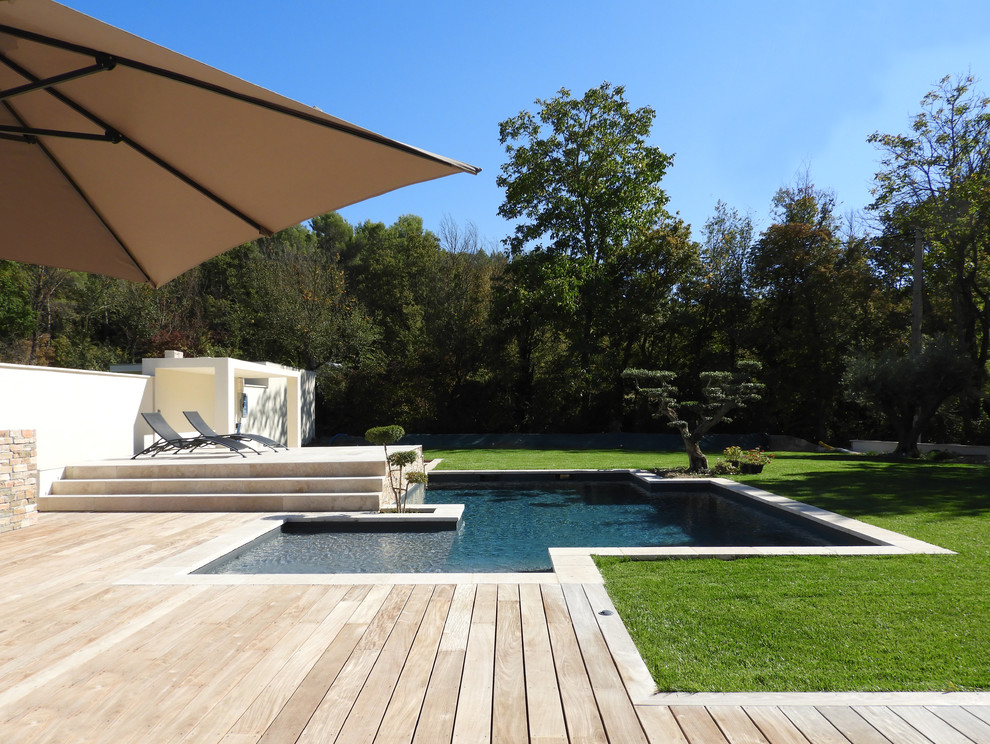 Inspiration pour une piscine design sur mesure avec une terrasse en bois.