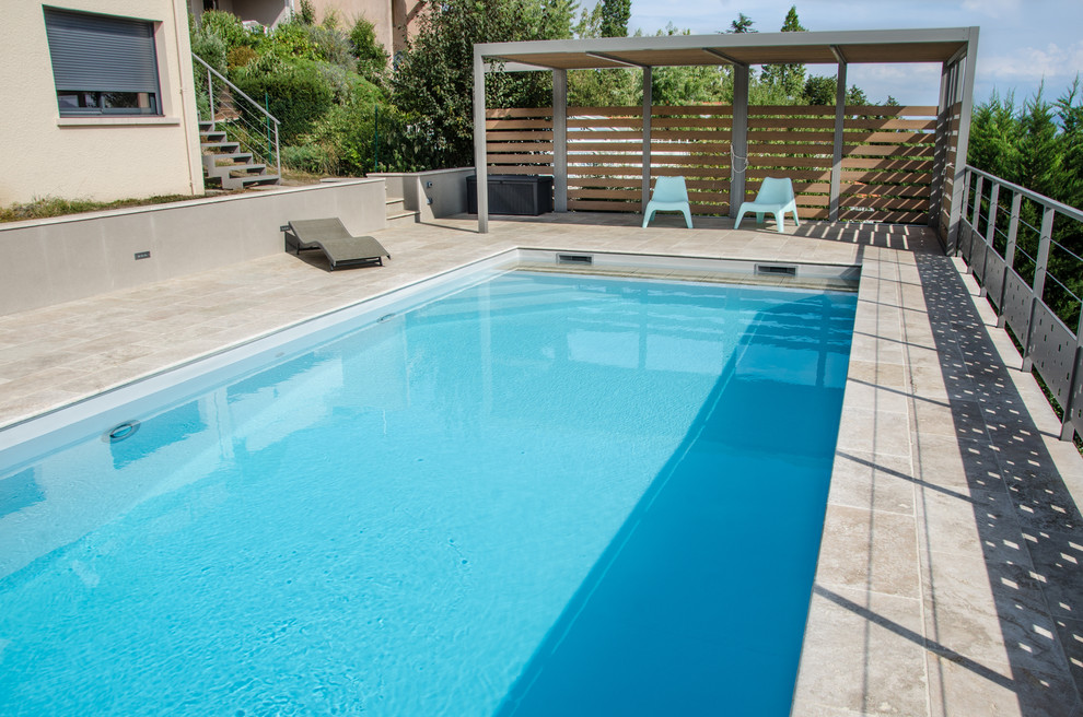 Cette image montre une piscine arrière minimaliste de taille moyenne et rectangle avec du carrelage.