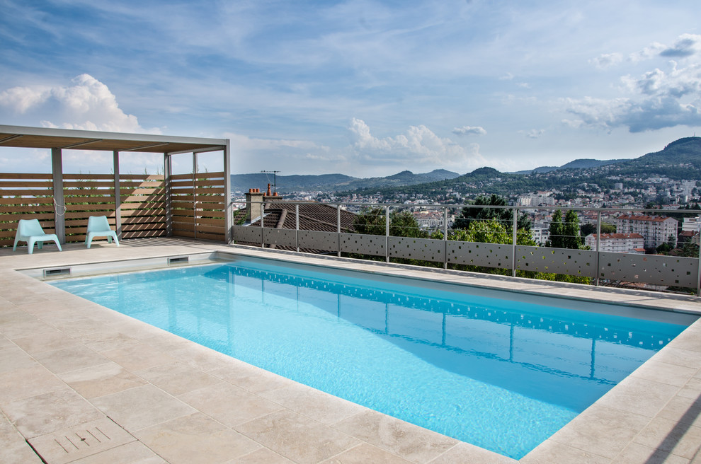 Imagen de piscina alargada moderna de tamaño medio rectangular con suelo de baldosas