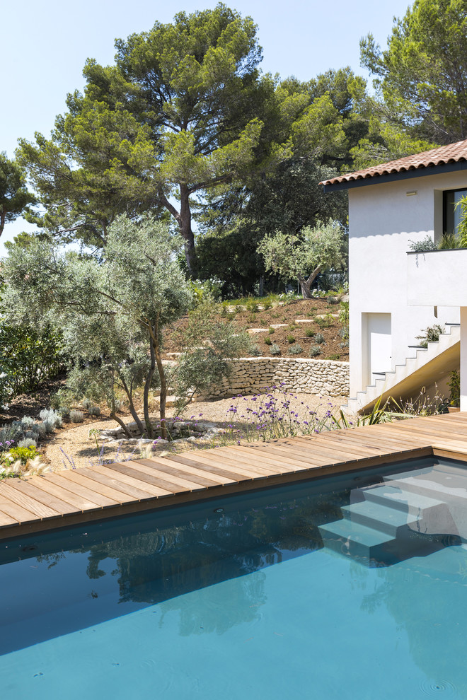 Aménagement d'un couloir de nage arrière méditerranéen rectangle avec une terrasse en bois.