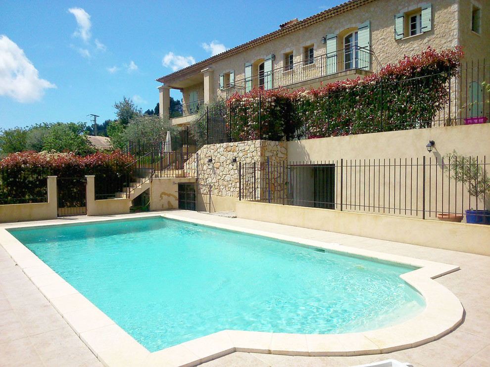 Foto di una piscina naturale mediterranea rettangolare di medie dimensioni e davanti casa con piastrelle
