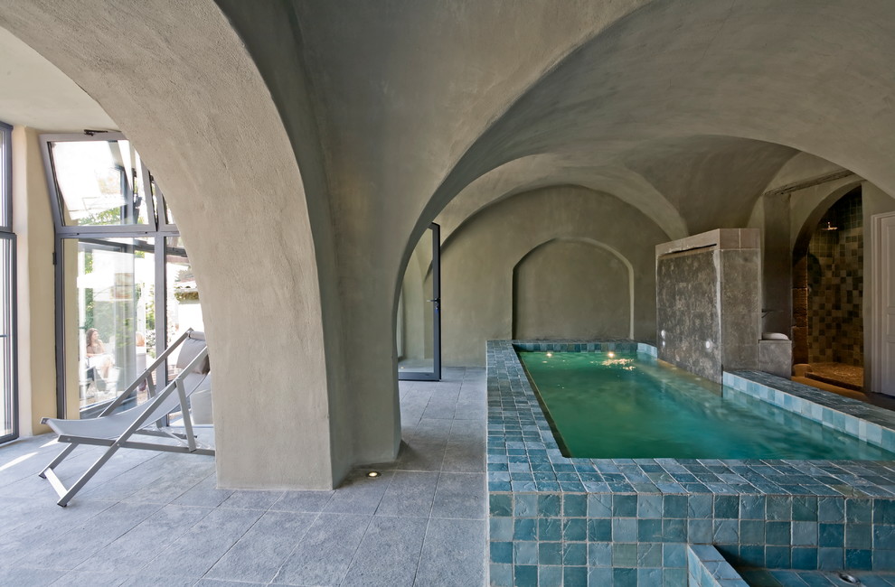 Diseño de piscina mediterránea de tamaño medio rectangular y interior con adoquines de piedra natural