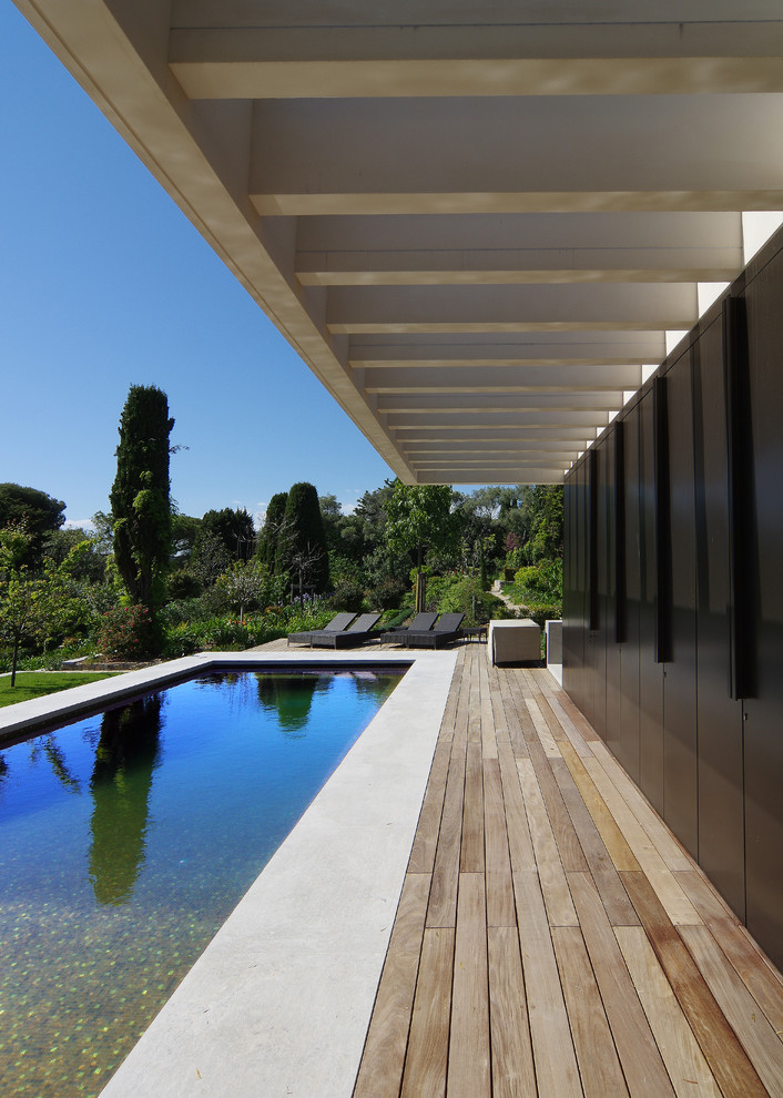 Immagine di una piscina monocorsia moderna rettangolare davanti casa con una dépendance a bordo piscina e pedane