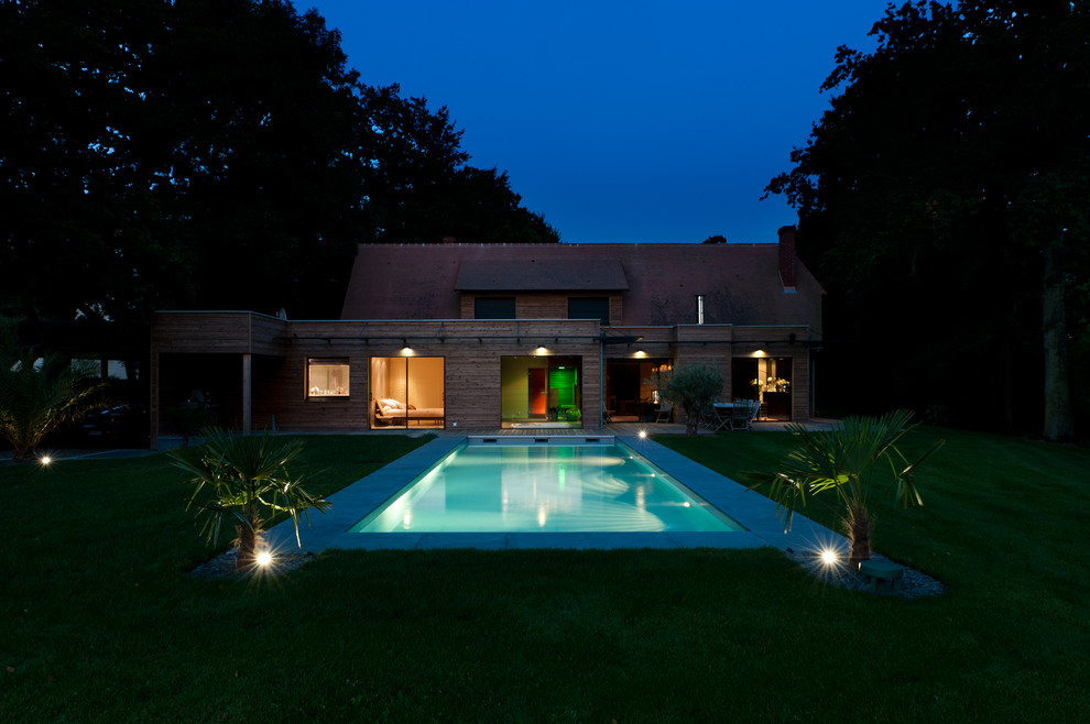 Esempio di una piscina monocorsia design rettangolare di medie dimensioni e dietro casa con pedane