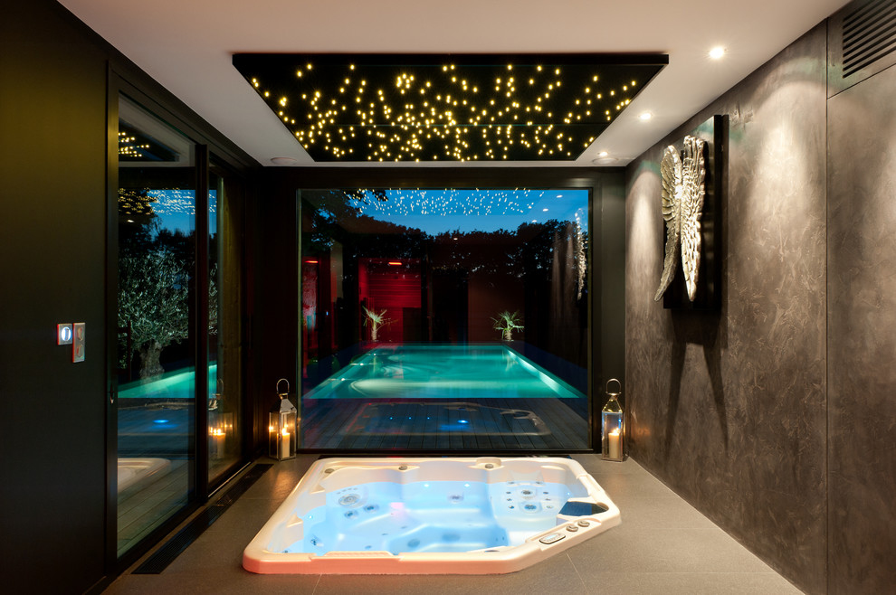 Idée de décoration pour une grande piscine design rectangle avec un bain bouillonnant.