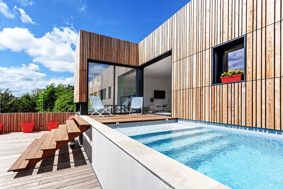 Esempio di una piscina design rettangolare nel cortile laterale con una dépendance a bordo piscina e pedane