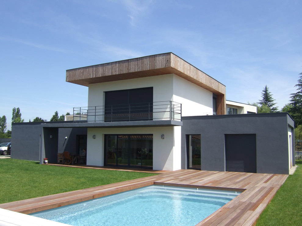 Exempel på en mellanstor modern rektangulär pool på baksidan av huset, med trädäck