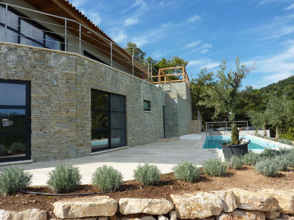 Ispirazione per una piscina mediterranea rettangolare di medie dimensioni e dietro casa con pavimentazioni in pietra naturale