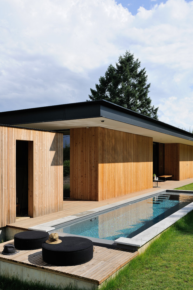 Inspiration pour un grand couloir de nage arrière design rectangle avec une terrasse en bois.