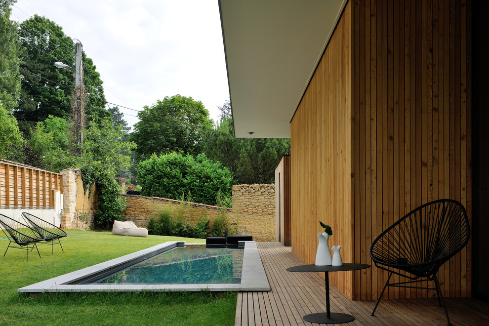 Immagine di una piscina monocorsia minimal rettangolare di medie dimensioni e dietro casa con pedane