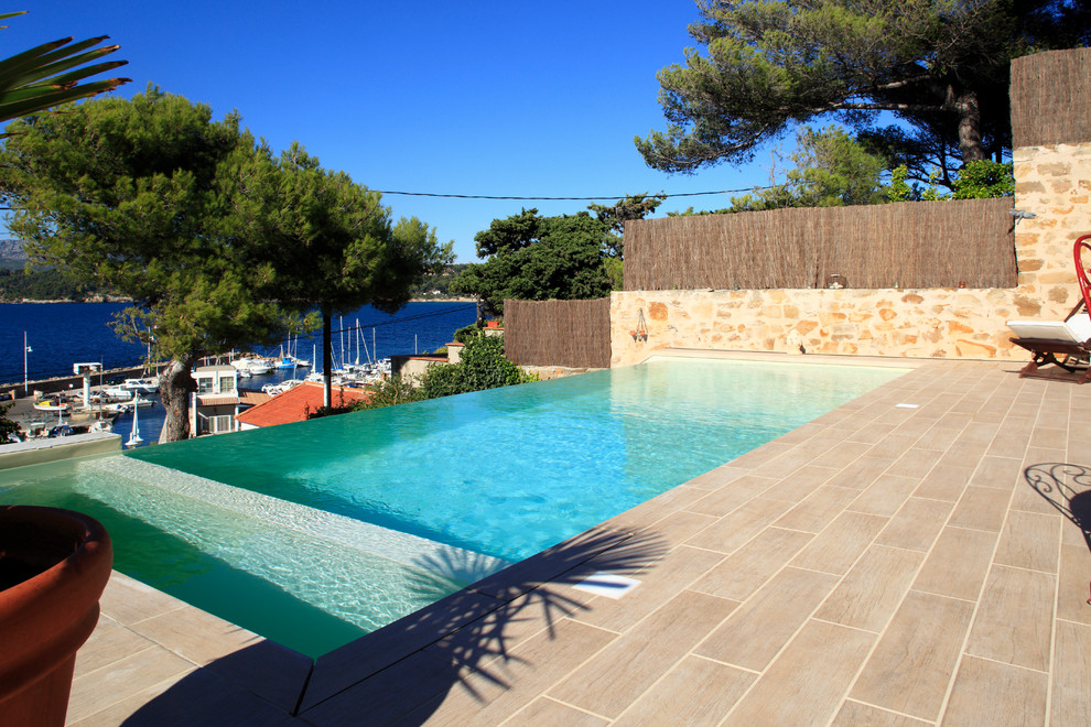 На фото: маленький прямоугольный бассейн-инфинити в современном стиле с покрытием из плитки для на участке и в саду