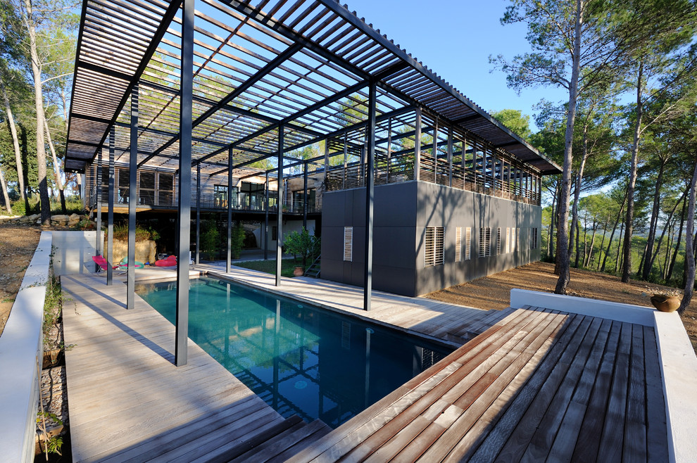 Ejemplo de piscina alargada contemporánea grande rectangular en patio trasero con entablado