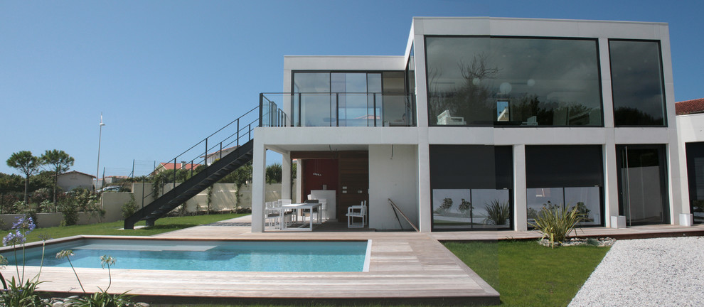 Immagine di una piscina monocorsia minimalista rettangolare nel cortile laterale con pedane